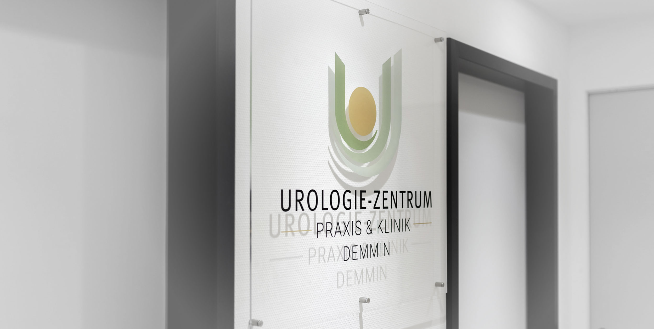 Das Logo der Arztpraxis ist in attraktiver Form auf eine Plexoglasplatte gedruckt, die im Eingangsbereich der Praxis angebracht ist.